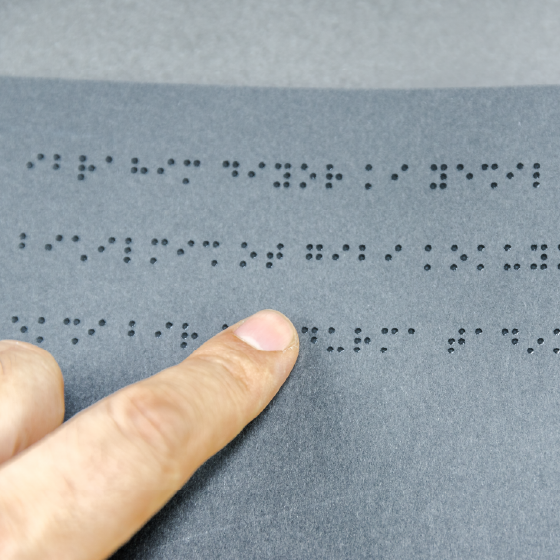 dedo tateando pontos em braille